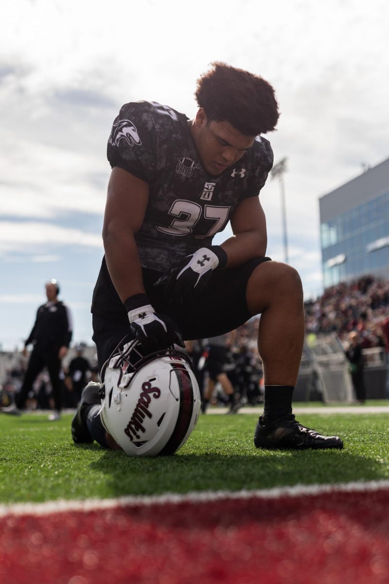 Miles Wash (37) kneels in the endzone in prayer moments before the Salukis annual Blackout Cancer game Nov. 4, 2023 at Saluki Stadium in Carbondale, Illinois.