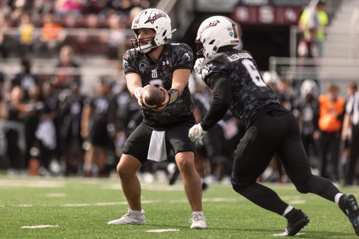 Quarterback Nic Baker (8) hands off the ball to running back Justin Strong (6) in the first drive of the game Nov. 4, 2023 at Saluki Stadium in Carbondale, Illinois. 