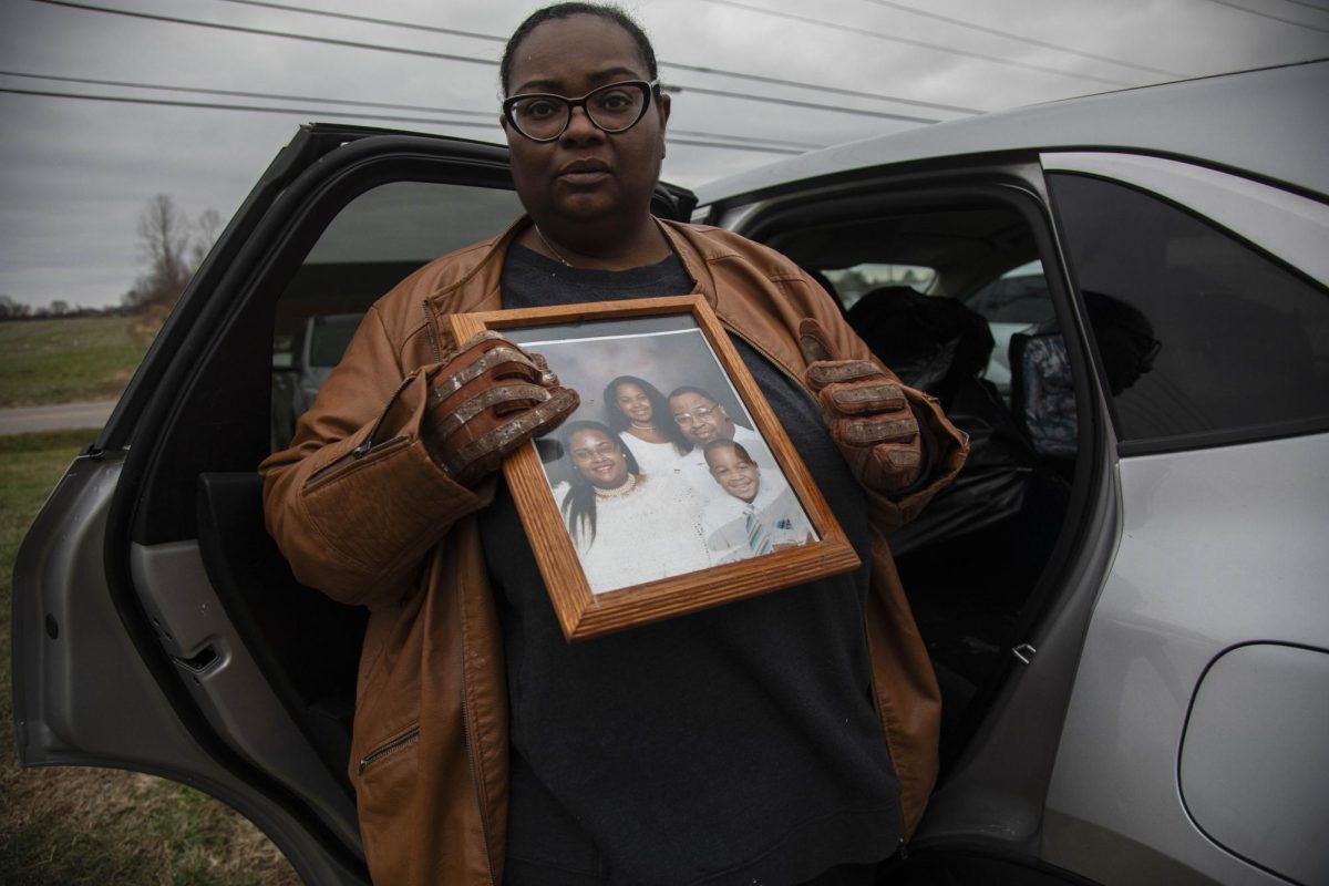 Sheryl McCoy holds a family photo that includes her deceased son Marcellus that she was able to save from the wreckage of her home Dec. 10, 2023 in Clarksville, Tennessee. 