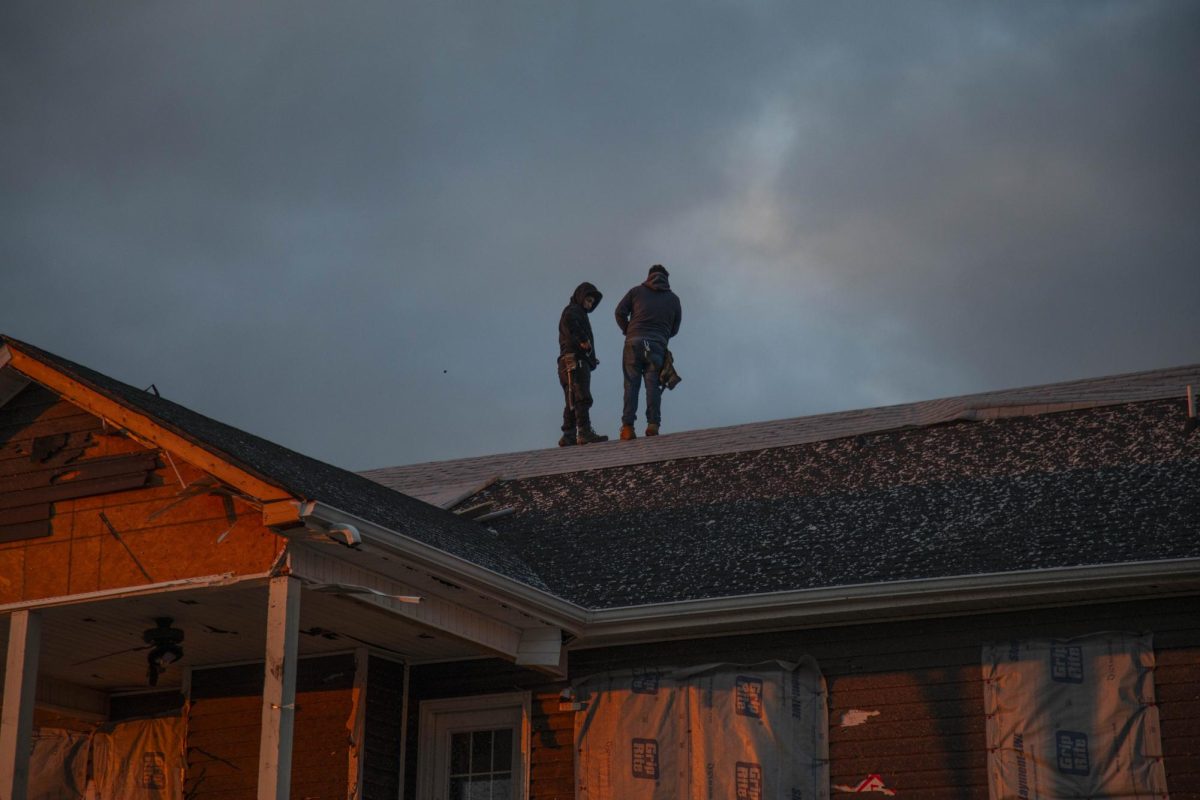 Two men stand on the roof of a home that was damaged by the Clarksville tornado the day prior Dec. 10, 2023 in Clarksville, Tennessee. 