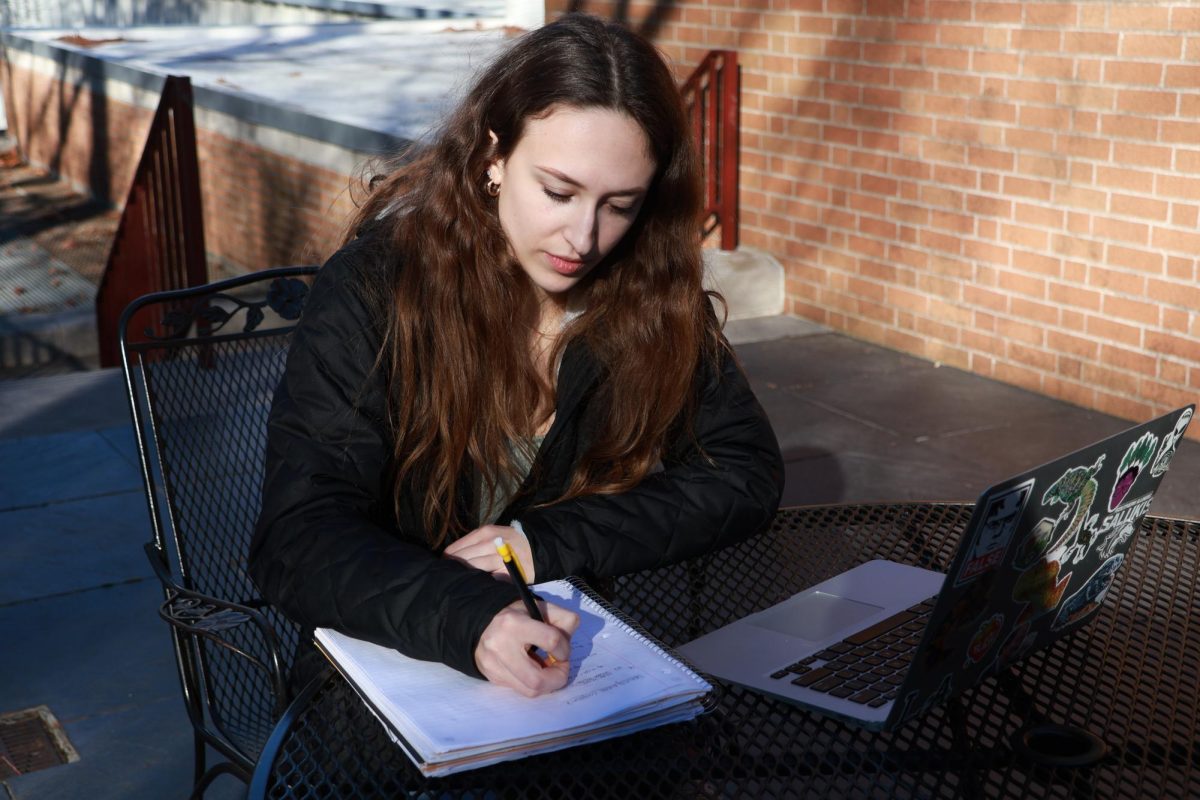 Liz Forassiepi takes down notes from a lecture while enjoying the outdoor weather Jan. 26, 2024 in Carbondale, Illinois. 
