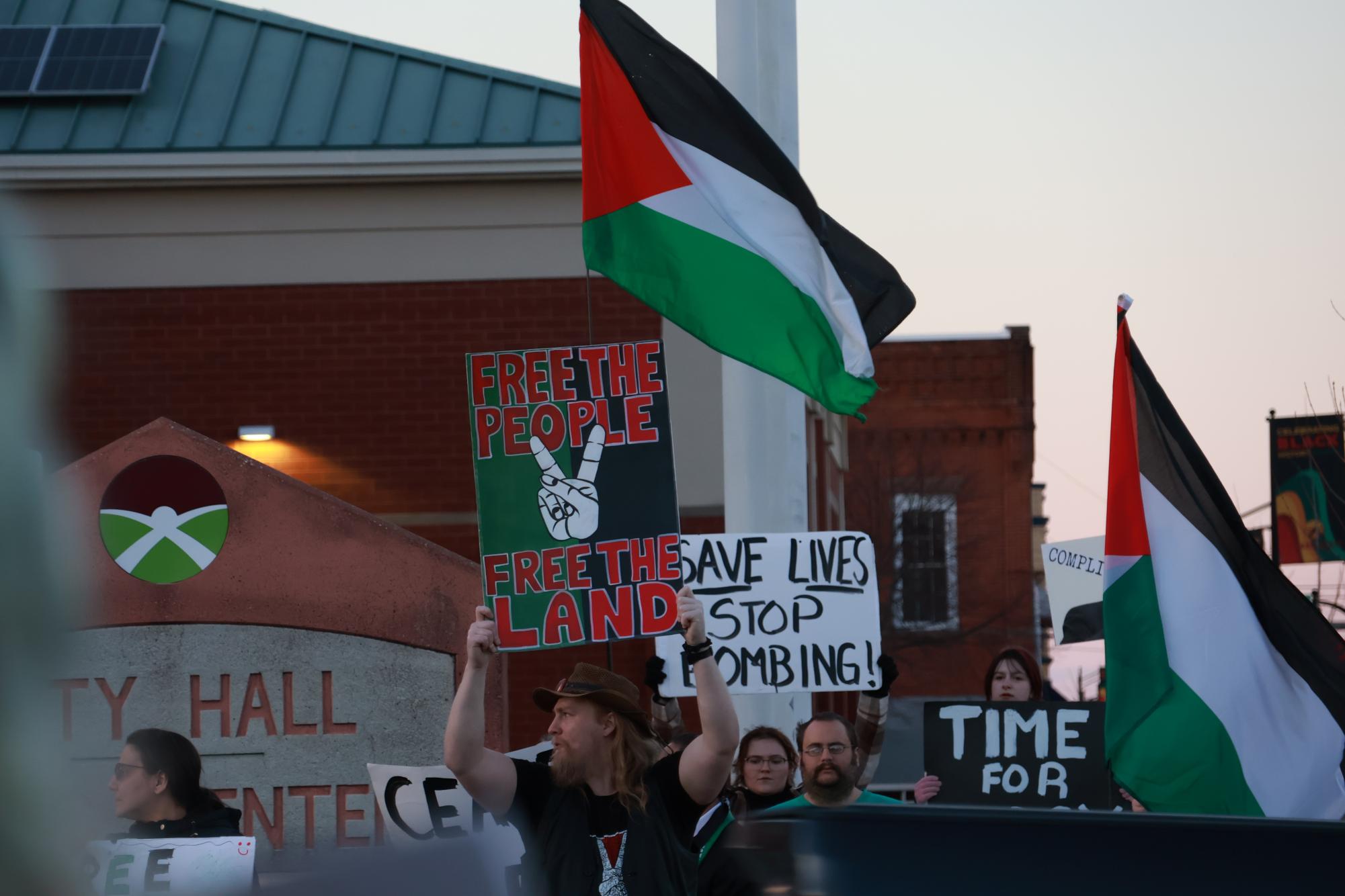 Joseph Behan holds up a sign reading “Free The People, Free The Land” in support of a ceasefire in Gaza during the protest Feb. 13, 2024 in Carbondale, Illinois. 
