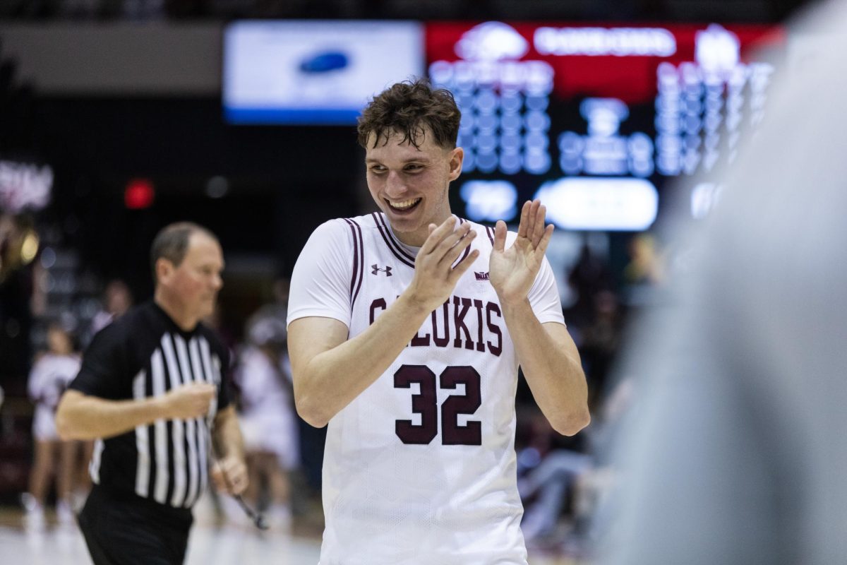 Jarrett Hensley (32) claps in celebration as the clock runs out to give SIU the win over Murray State Feb. 21, 2024 at Banterra Center in Carbondale, Illinois.