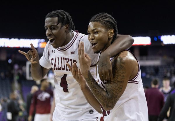 Clarence Rupert (4) and AJ Ferguson (14) celebrate on the way to the locker room after the Salukis take the conference win over the Purple Aces Feb. 25, 2024 at Ford Center in Evansville, Indiana. 