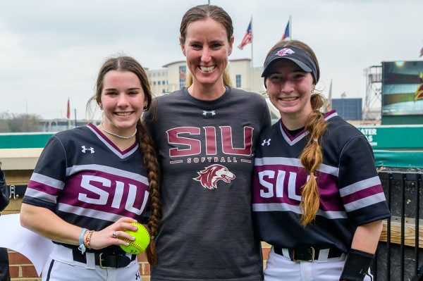 Pitcher Maddia Groff (left), pitching coach Katie Griffith (center), and catcher Rylinn Groff (right) pose with the game ball from Maddia Groffs perfect game Feb. 9, 2024 at Bobcat Softball Stadium in San Marcos, Texas. Photo provided by Saluki Athletics.