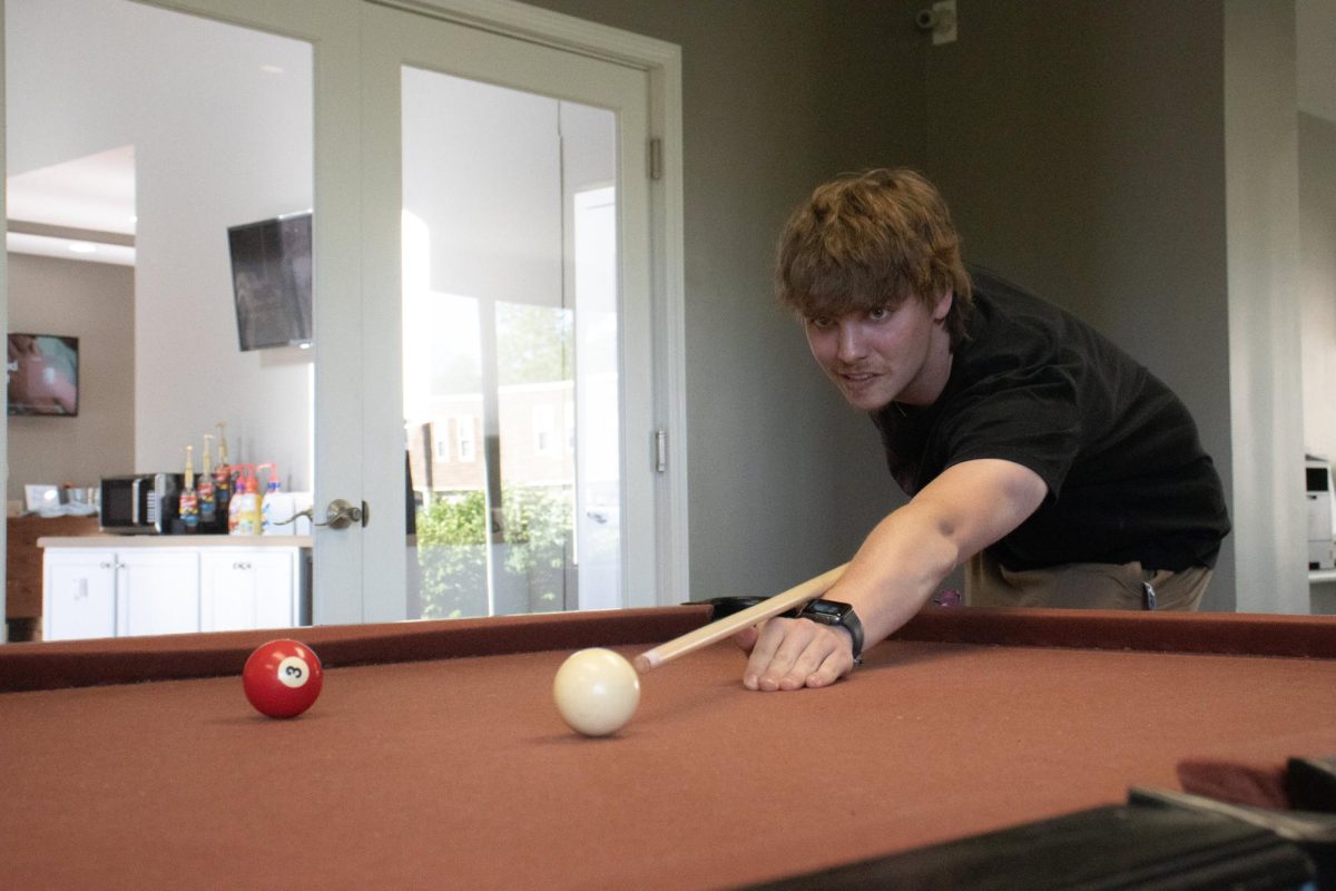 Junior Keegan Montgomery hits the cue ball in the recreation room at University Village Apartments April 17, 2024 in Carbondale, Illinois. 