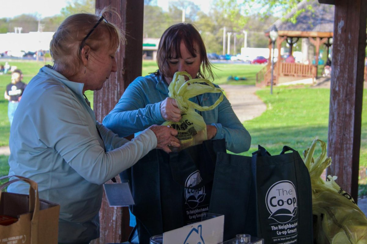 Twins, Patty Mullen (left) and Sue Mullen (right) go through donations that were donated by runners for the Good Samaritan House of Carbondale during the Feed Your Neighbor 5K at Turley Park April 12, 2024 in Carbondale, Illinois.  | @libbyphelpsphotography
