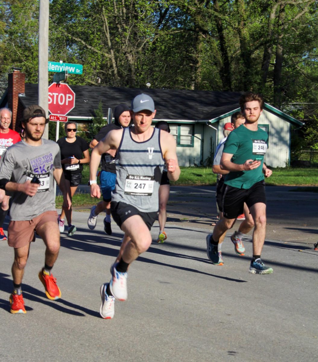 Micah Cherry runs through the start line during the Feed Your Neighbor 5K that was held by the Neighborhood Co-op Grocery at Turley Park April 12, 2024 in Carbondale, Illinois. | @libbyphelpsphotography
