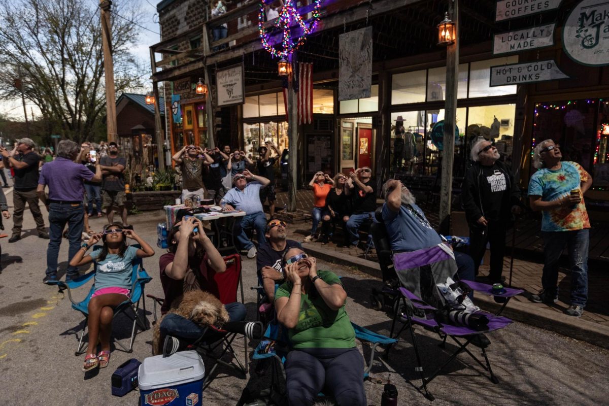 Makanda residents and visitors from all over gather in front of the boardwalk to view the solar eclipse as it nears totality April 8, 2024 in Makanda, Illinois