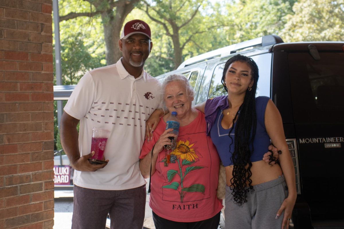 Chancellor Austin Lane stands next to freshman Heavenly Davis and her grandmother under the walkway between Neely and Trueblood. "I'm excited to further my education for sure, and well everything else," Davis says.