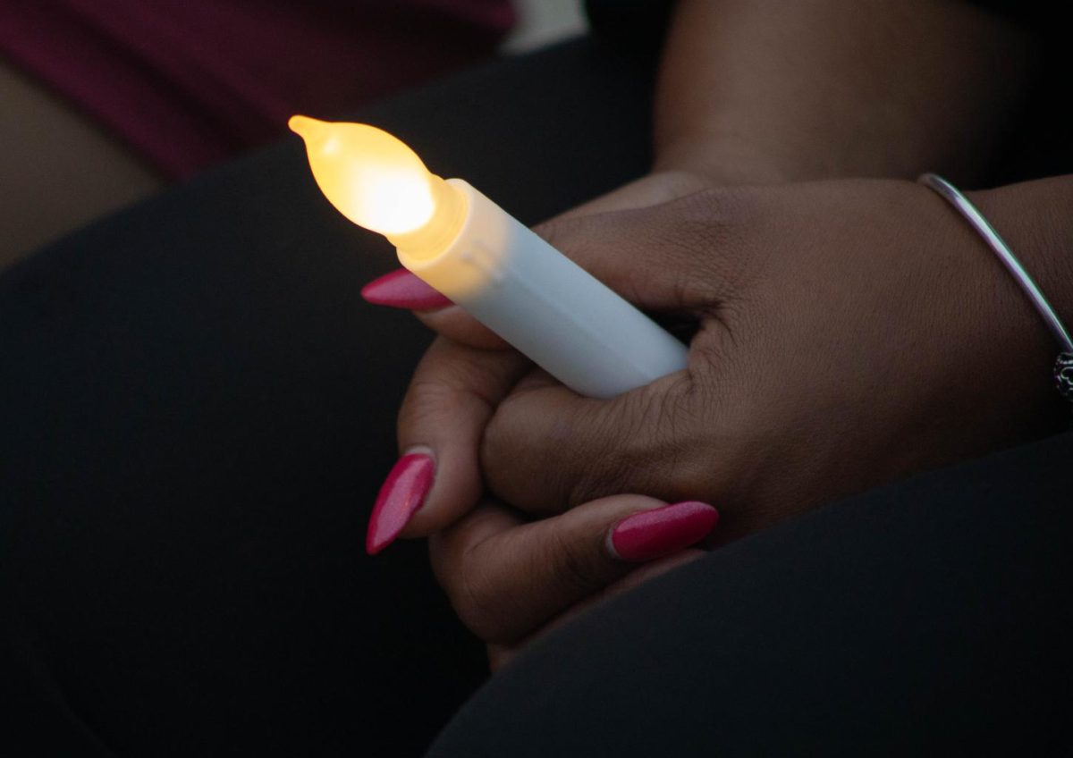 An attendee of the “Once a Saluki, Always a Saluki” remembrance event holds onto an electric candle in her hands Sept. 30, 2024 at Becker Pavilion on Campus Lake in Carbondale, Illinois. 