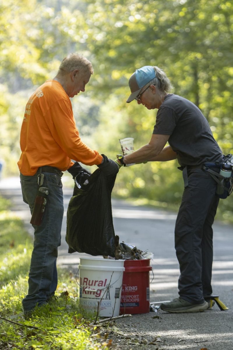 Pat Jones (left) and Shelley Deals (right) put trash into a trash bag along the road near Grantsburg Swamp Oct. 4, 2024 in Grantsburg, Illinois.
