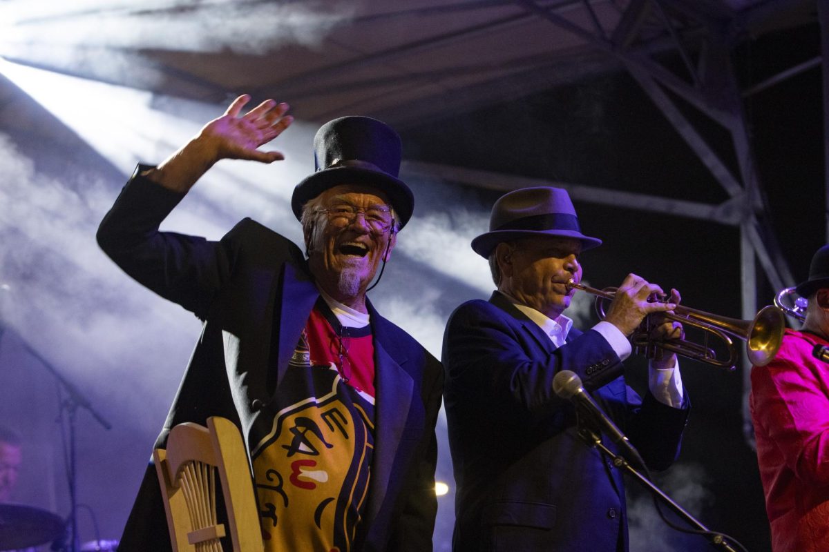 D. Ward (left) waves at the crowd that came to watch the Jungle Dogs perform while Keith Huffman (right) plays with the band Oct. 11, 2024 in Carbondale, Illinois.