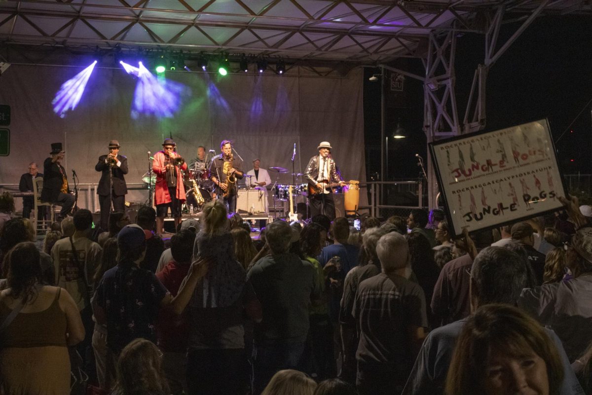 Jack Wissman holds up a sign during the Jungle Dog’s final performance to a crowd of people Oct. 11, 2024 at The Strip in Carbondale, Illinois.