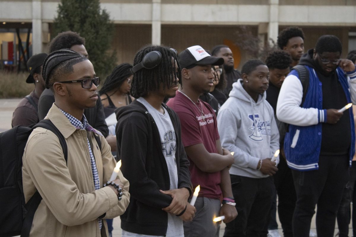 Students and community members hold electronic candles at the vigil for Lyric Irby Oct. 22, 2024 on the steps of the Parkinson Building at SIU in Carbondale, Illinois.