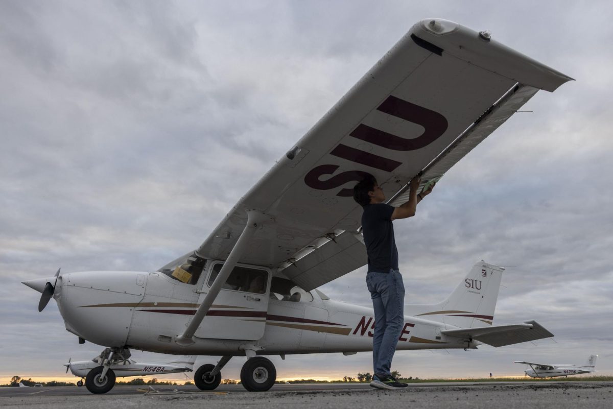 Sophomore aviation student Joshua Vargas checks the wing of a Cessna 172 plane as he runs through his pre-flight checklist for an upcoming night flight Sept. 30, 2024 at the SIU School of Aviation in Murphysboro, Illinois.