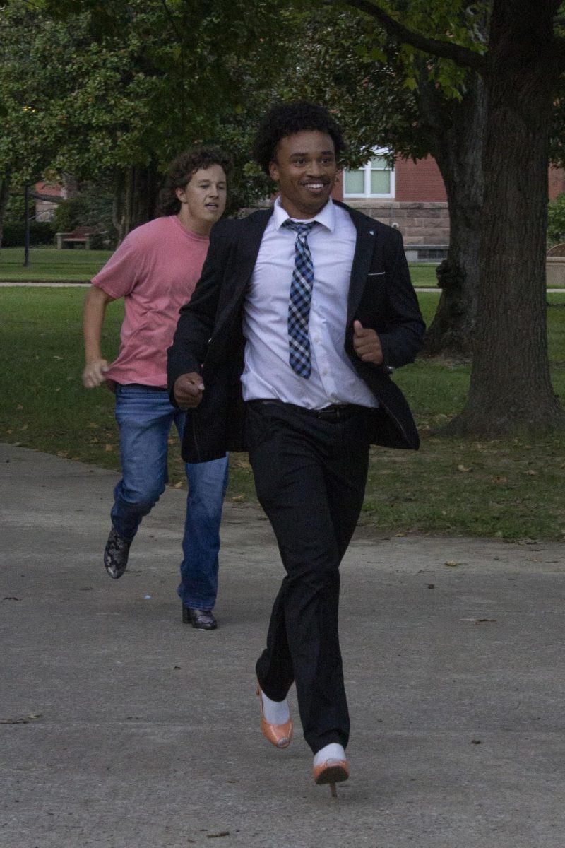 Sigma Chi pledge Rodney Brown runs through campus wearing heels during the third annual Walk a Mile in Their Shoes charity event Oct. 3, 2024 in Carbondale, Illinois.