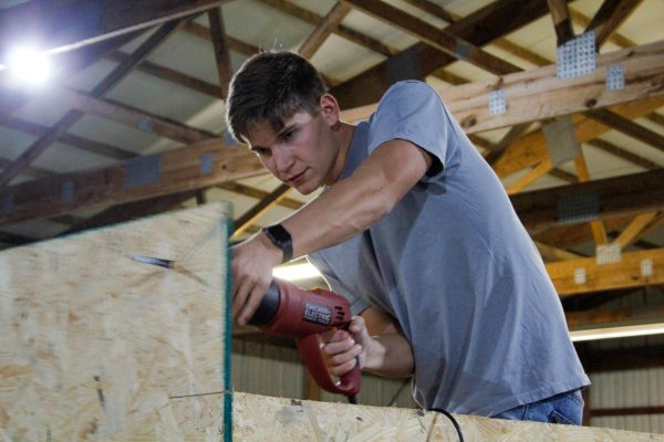 Member of Alpha Gamma Rho, Zach Kampwerth uses an electric saw on the Alpha Gamma Rho and Sigma Alpha homecoming float Oct. 9, 2024 in Carbondale, Illinois. 