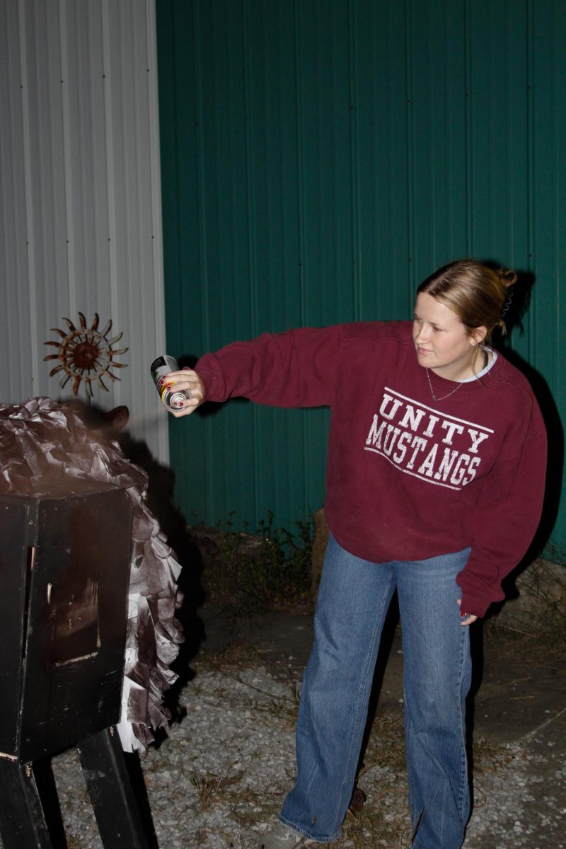 Sigma Alpha member Audrey Bruening spray paints a wooden horse for the Alpha Gamma Rho and Sigma Alpha homecoming float Oct. 9, 2024 in Carbondale, Illinois. 