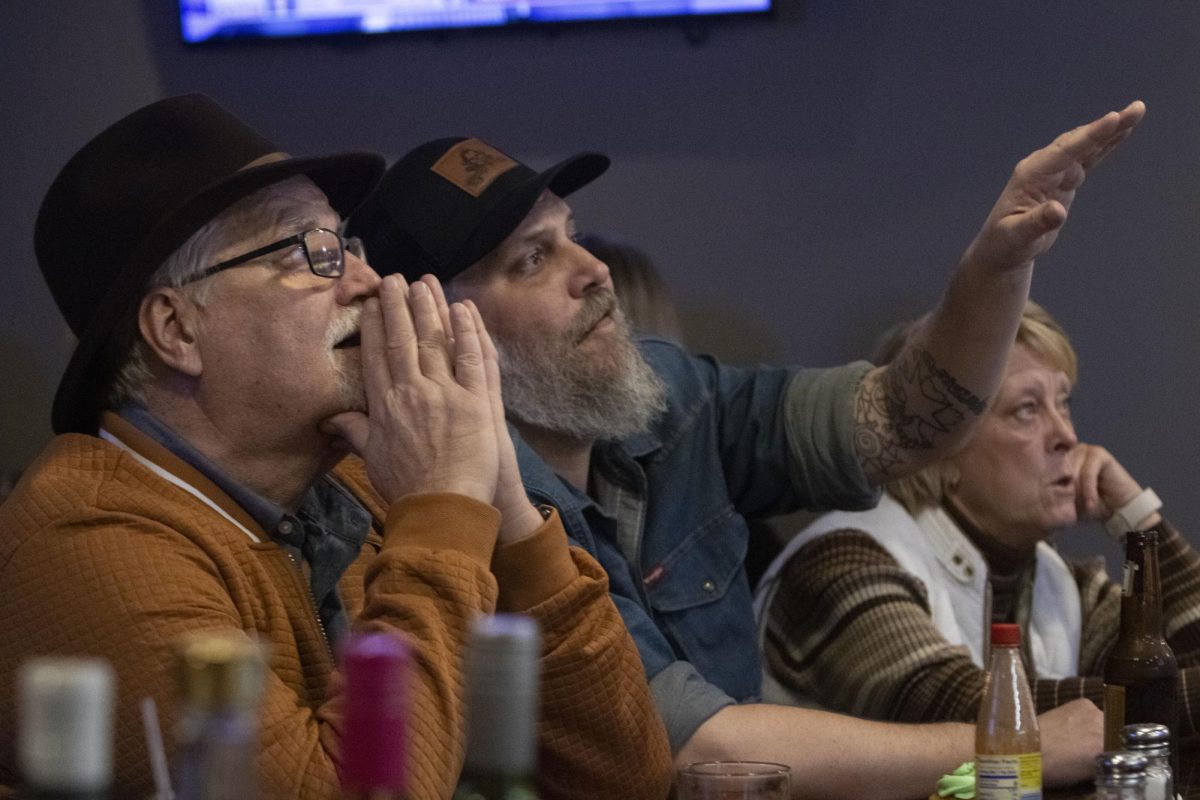 Jerry Ross (left) and his son Brandon Ross (right) drink a beer and watch the polls at a watch party Nov. 5, 2024 at the Grecian Steakhouse in Pinckneyville, Illinois.