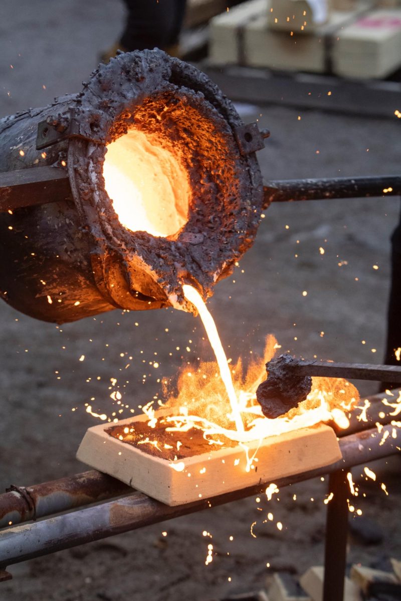 Molten iron flies off of a cast that was freshly made Nov. 9, 2024 at the Art Foundry in Carbondale, Illinois.