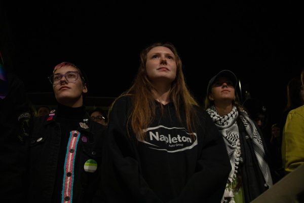 Three attendees of the Pride in Unity event listen on as several speakers talk to the masses about what is to come and what to anticipate in the next coming years of the upcoming Trump presidency Nov. 8, 2024 at the Carbondale Civic Center in Carbondale, Illinois.