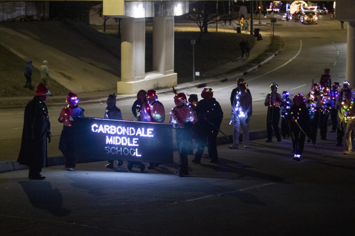 The Carbondale Middle School marching band walks toward the Carbondale strip from Mill street Dec. 7, 2024 in Carbondale, Illinois.