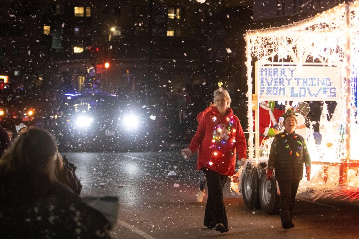 Visitors to the Lights Fantastic Parade watch the Lowe’s float as it passes Dec. 7, 2024 on the Strip in Carbondale, Illinois.