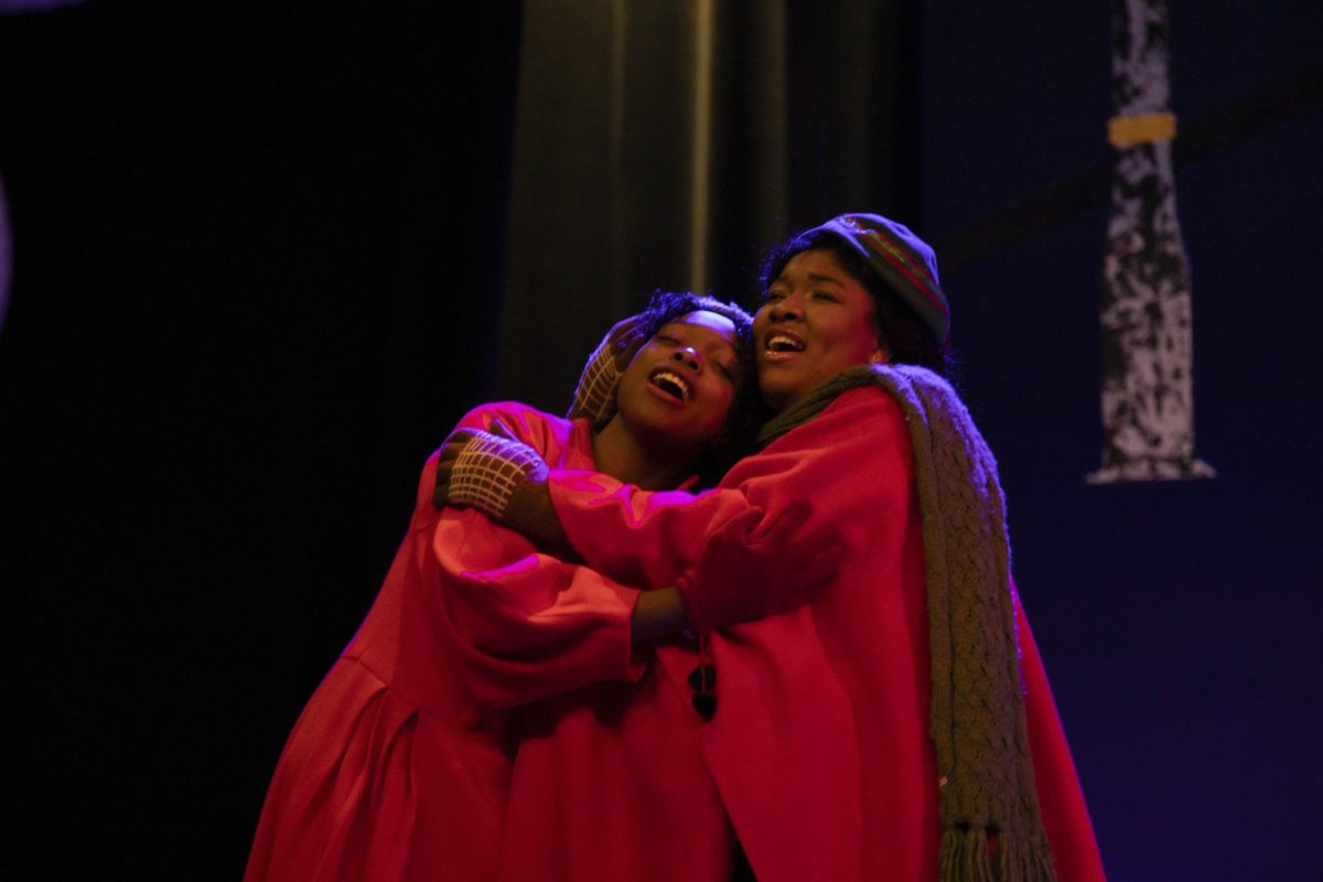 Makyla Mobley and Israeli Jones hug each other as they practice O Holy Night before running the show for dress rehearsal Dec. 4, 2024 at the McLeod Theater in Carbondale, Illinois. “I feel like I'm always mothering someone, so it wasn't difficult,” Jones said about playing the mother of the Cratchit family. 