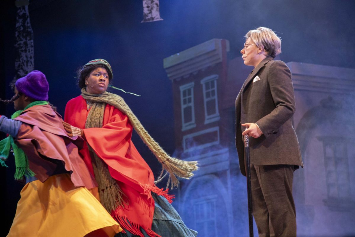 A pregnant Mrs. Crachit (Israeli Jones) pulls away her daughter Belinda Cratchit (Yasmin Martinez-Powell) from Ebenezer Scrooge (Sawyer Richman) Dec. 4, 2024 at McLeod Theater in Carbondale, Illinois. “I based my Mrs. Cratchit off of my own mother because, my mom, in her later days, was pregnant. She already had four kids. So, and I was just like, ‘Yeah, she's done this already. I'm going to base my character off of her’,” Jones said. 