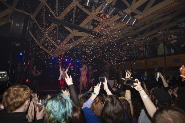 Confetti shoots into the air raining down on the crowd of attendees as the clock strikes midnight for the new year Jan. 1, 2025 at Hangar 9 in Carbondale, Illinois. The end of 2024 also marked the end of Hangar 9 as it celebrated its last night open.  