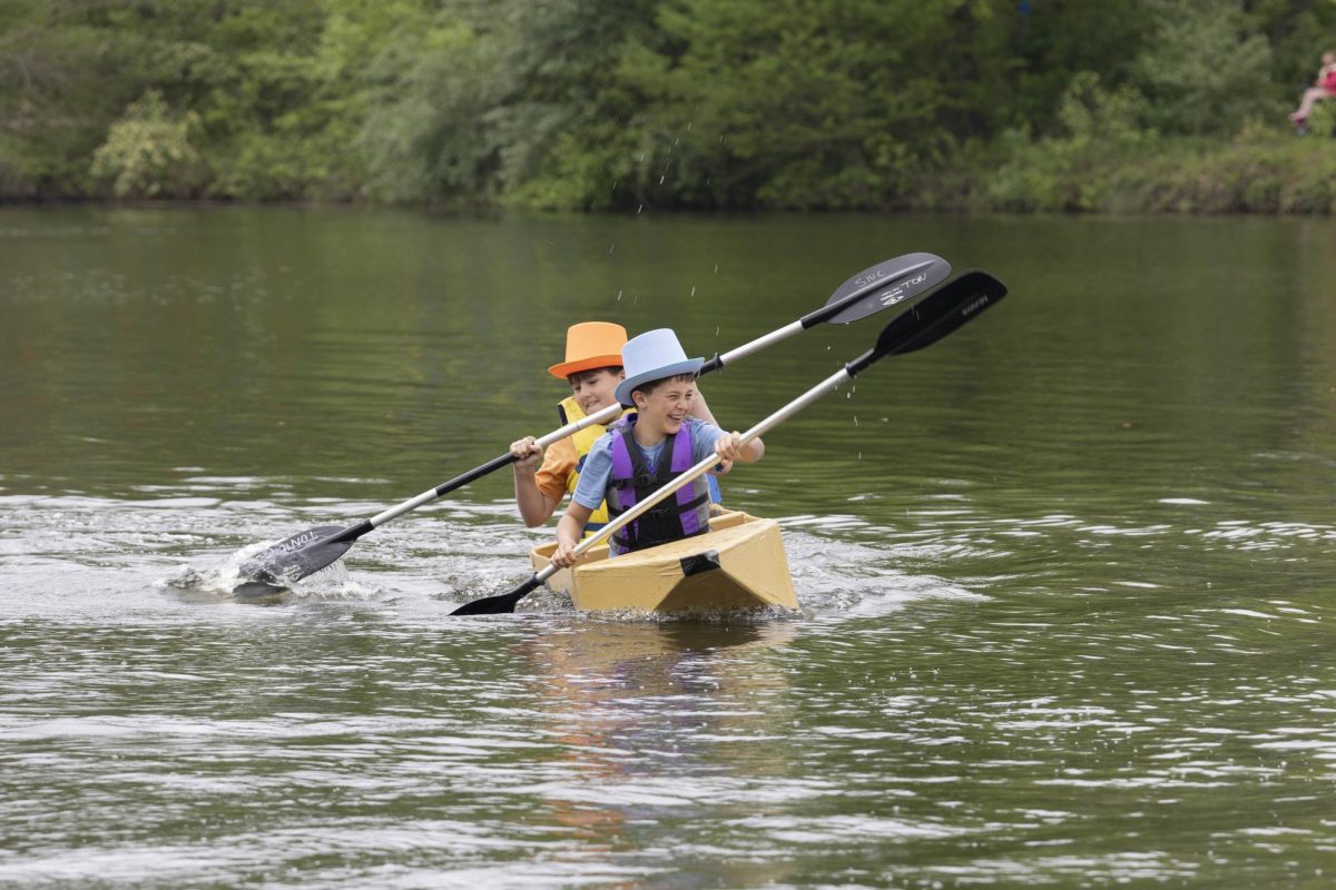 Nolan Slone and Cooper Jones paddle their way towards the first buoy in their boat called "Dumb and Dumb(car)" at the Cardboard Boat Regatta in campus lake April 26, 2025 in Carbondale, Illinois. 