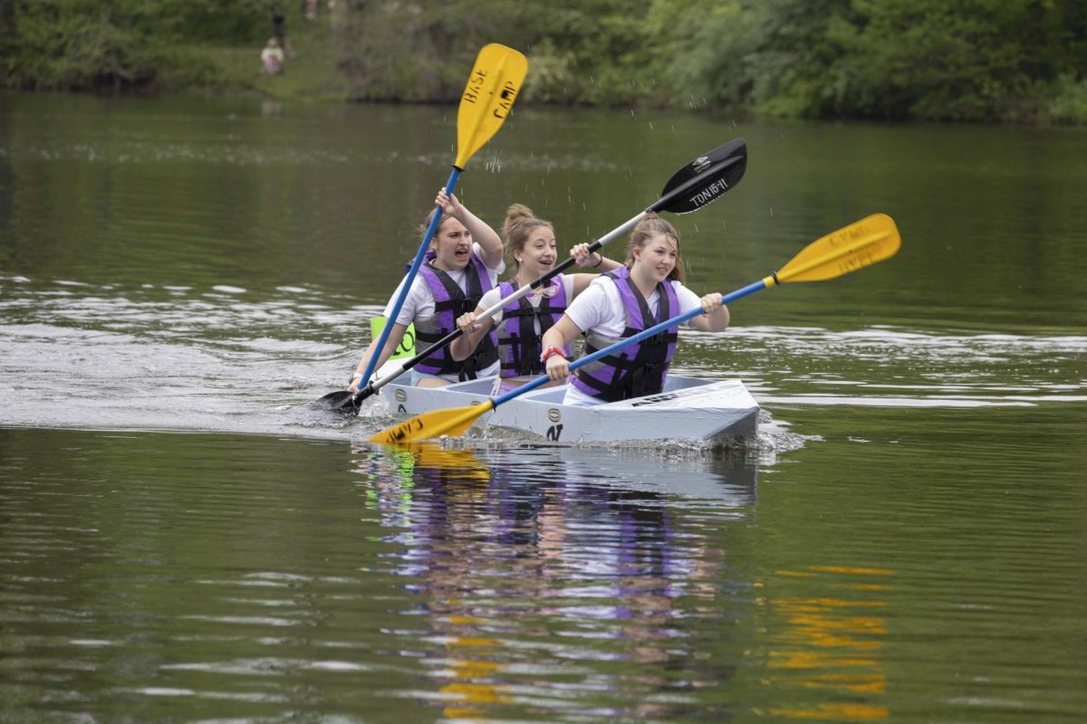 Beth's angels team Kinley Slone, Khloe Maple, and Olivia Maple paddle together towards the first buoy at the Cardboard Boat Regatta in campus lake April 26, 2025 in Carbondale, Illinois.