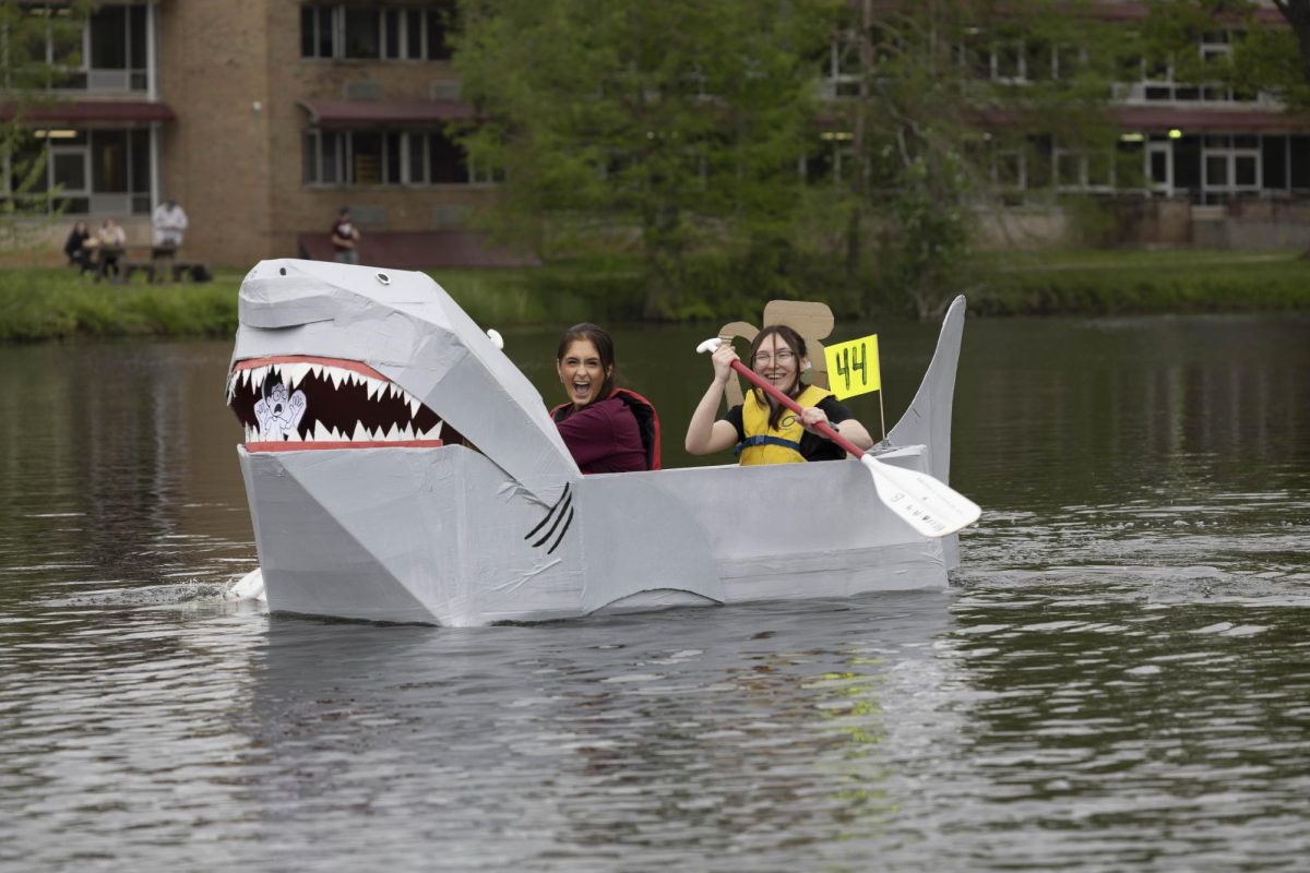 Mariah Fletcher, left, and Kassity Lee, right, paddle their way towards the first buoy at the Cardboard Boat Regatta in campus lake April 26, 2025 in Carbondale, Illinois.