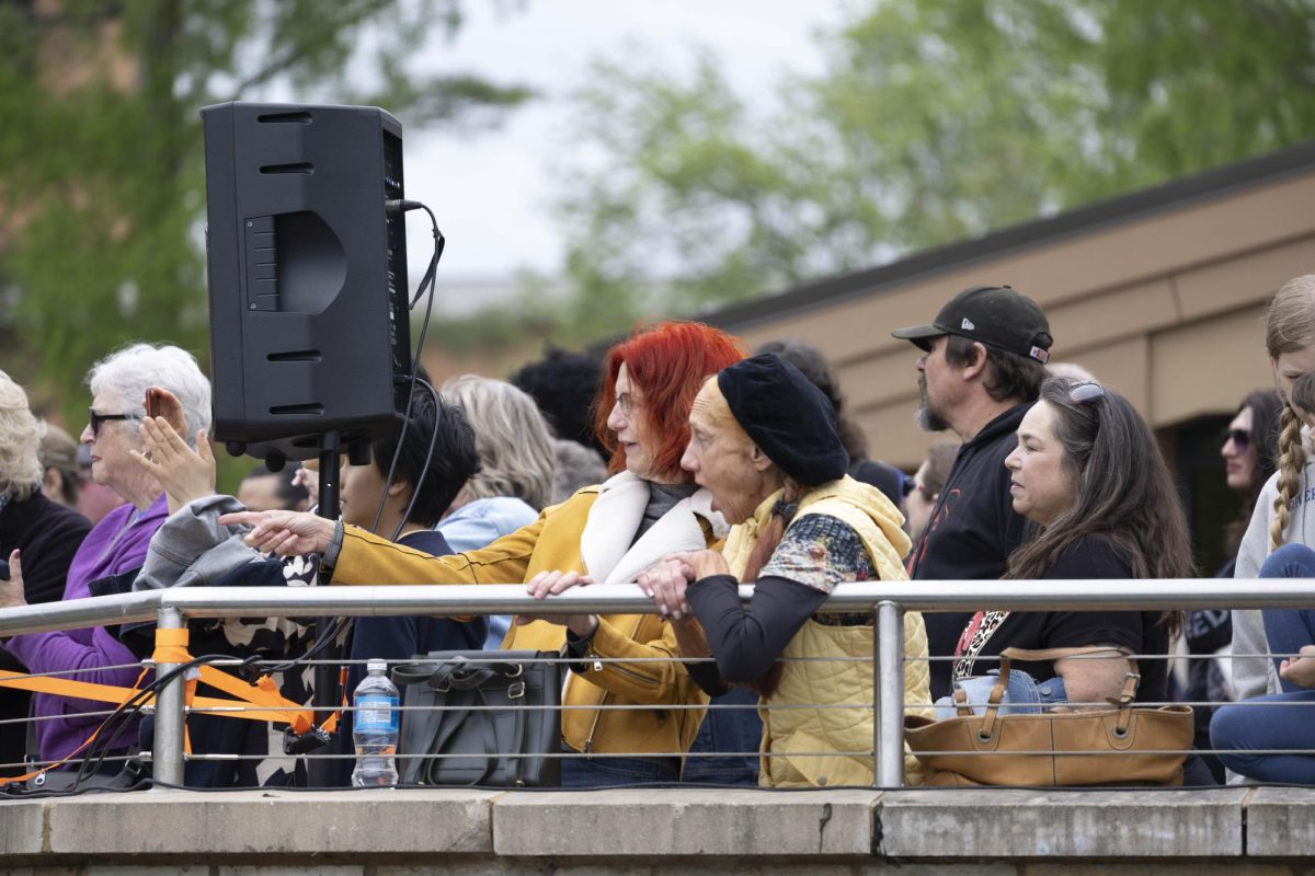 Spectators point and cheer towards the starting line at the Cardboard Boat Regatta April 26, 2025 Carbondale, Illinois. 