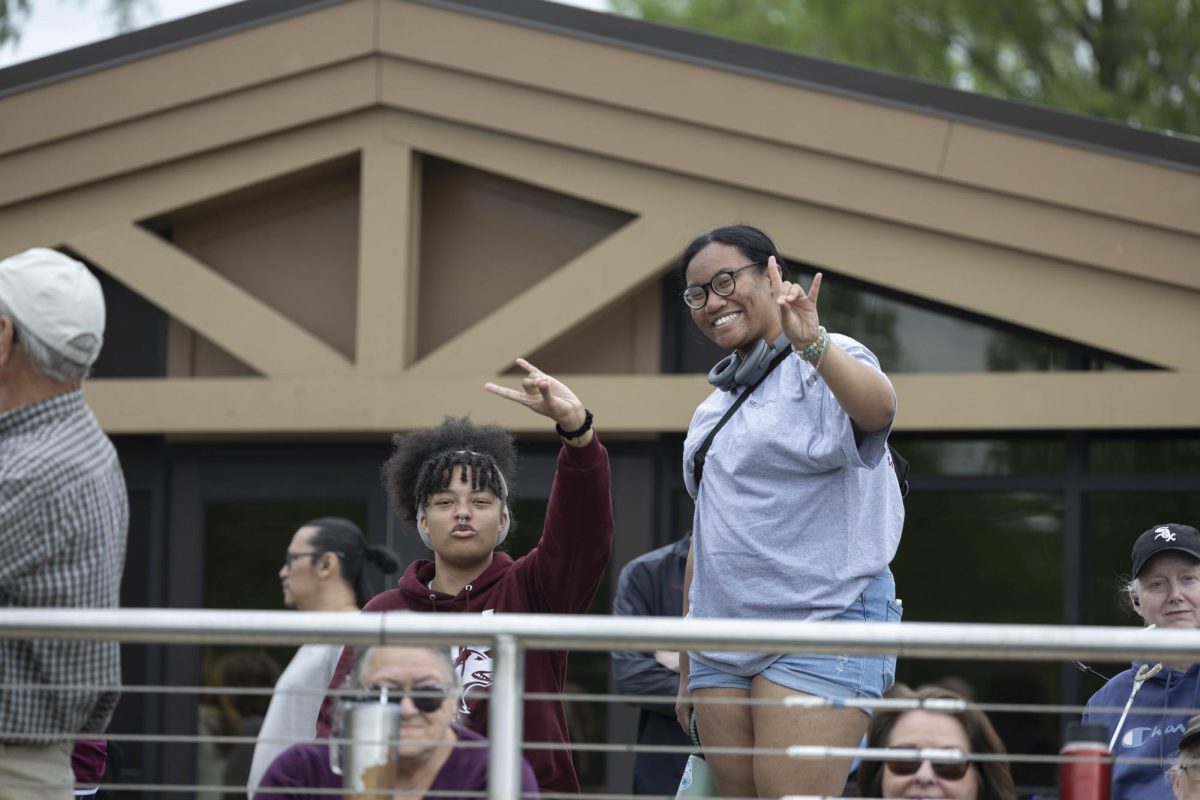 Megan Blohm, left, and Misona McKinney, right, smile towards the camera at the Cardboard Boat Regatta April 26, 2025 in Carbondale, Illinois. 