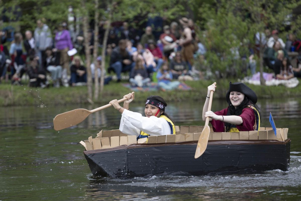 The Black Pearl team Elisa Lopez and Parker Handley paddle towards the first buoy at the 50th Annual Cardboard Boat Regatta in campus lake April 26, 2025 in Carbondale, Illinois. 