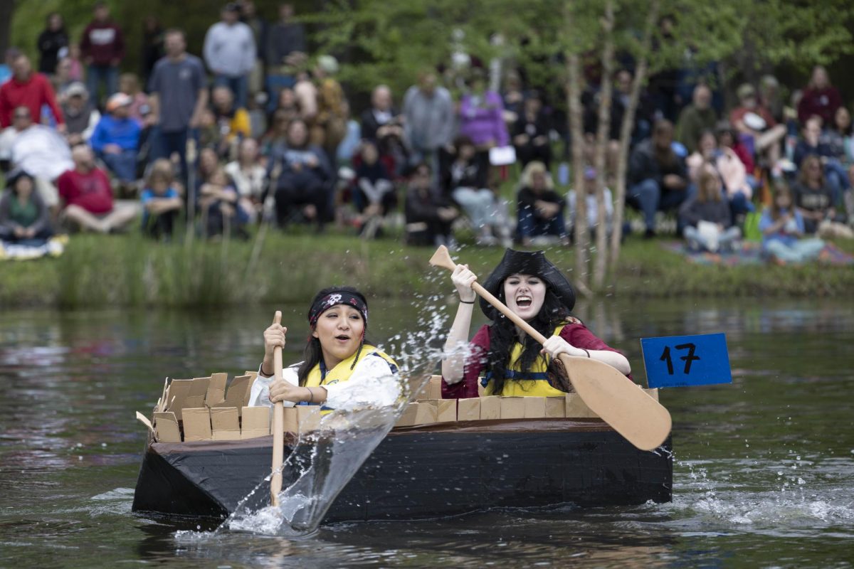 The Black Pearl team Elisa Lopez and Parker Handley paddle towards the first buoy at the 50th Annual Cardboard Boat Regatta in campus lake April 26, 2025 in Carbondale, Illinois. 