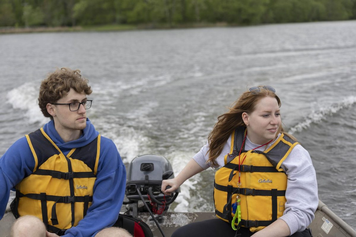 Levi Teague, left, and Kayley Otto, steer the speedboat towards the boats racing at the 50th Annual Cardboard Boat Regatta in campus lake April 26, 2025 in Carbondale, Illinois.