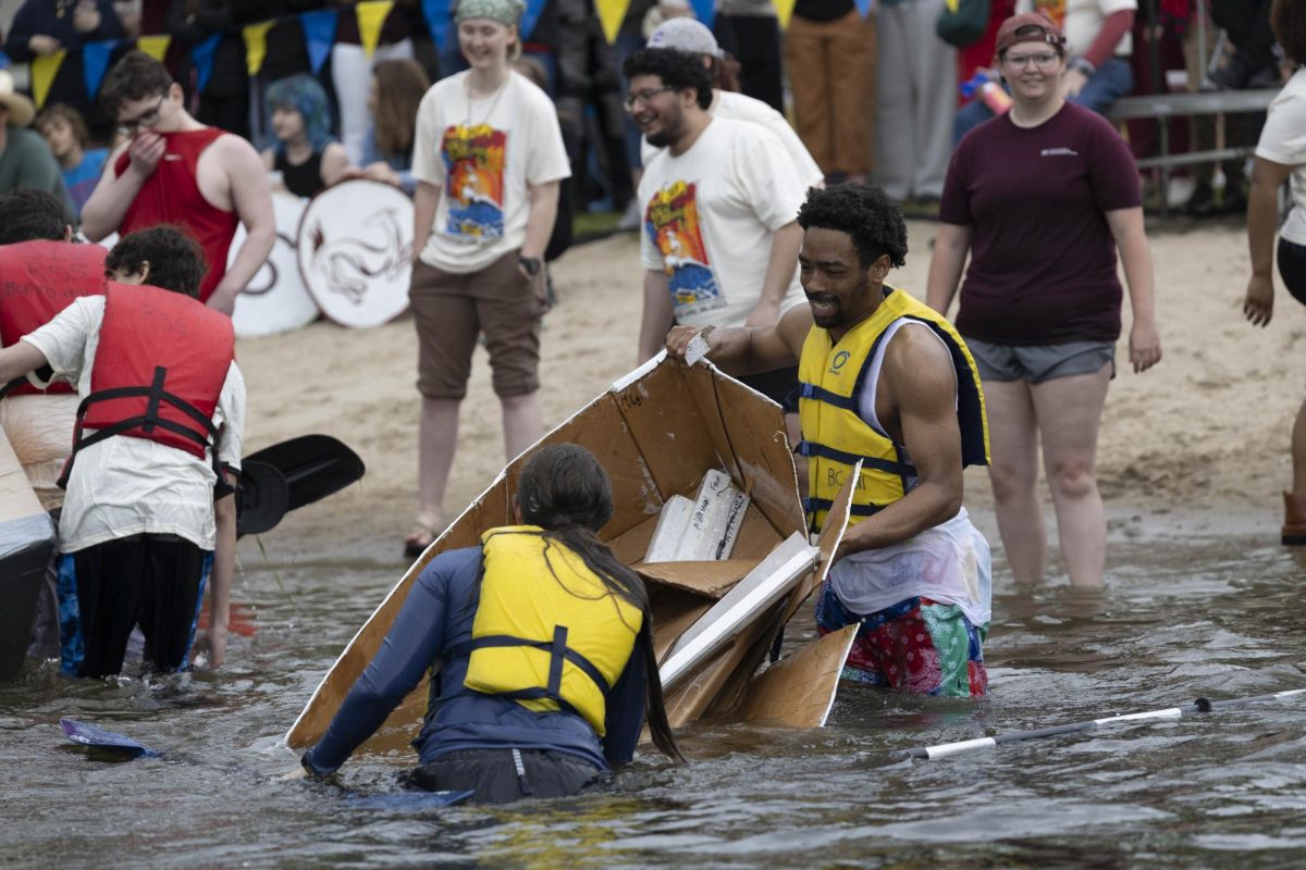 Goofy Goobers team Faith Loyd and Christian Smith pull their boat towards the shore at the Cardboard Boat Regatta in campus lake April 26, 2025 in Carbondale, Illinois. 