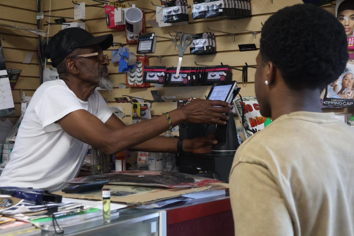 Rahim rings up a customer at Rahim’s Beauty Supply Sept. 27, 2025, in Carbondale, Ill. The rhythmic beep of the scanner mixes with quiet chatter as shoppers browse for oils, combs and hair.