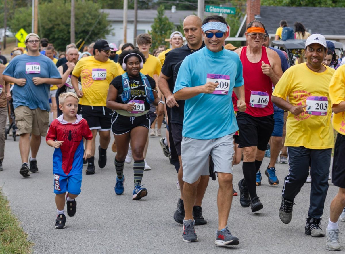 A child dressed as Spider-Man runs among a large group of people starting the Superhero 5K Run Sep. 20, 2025 at Turley Park in Carbondale, Illinois. 