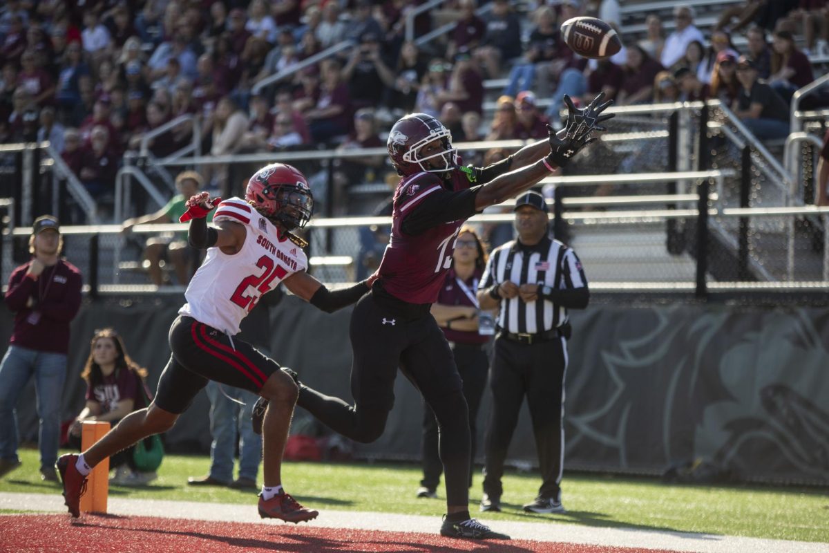 SIU wide receiver Jay Jones (13) reaches for the ball in the end zone as he is defended by defensive back RJ Stewart (25) of South Dakota Nov. 15, 2025 at Saluki Stadium in Carbondale, Illinois. 