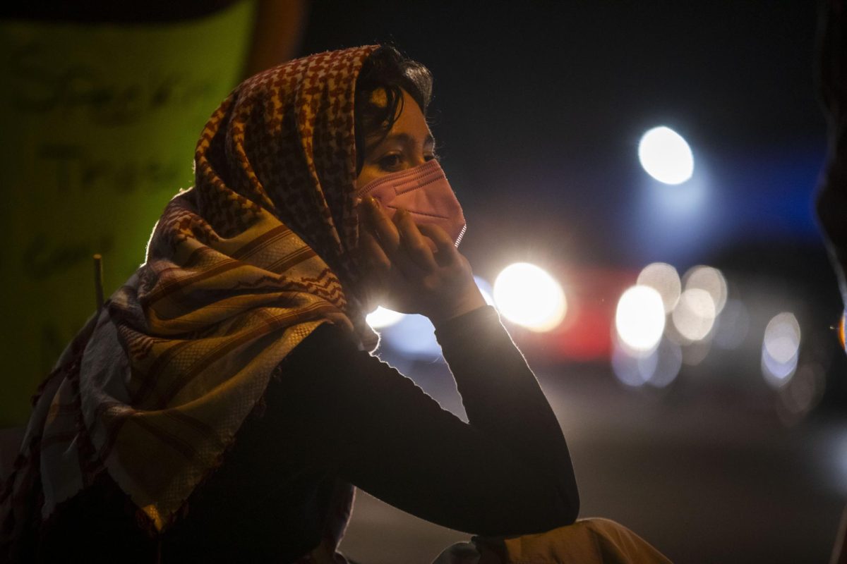 A protester sits on the corner of Lexington Street and 25th Avenue after Illinois State Police and protesters stood off outside of the US Immigration and Customs facility following the No Kings Protest Oct. 18, 2025 in Broadview, Illinois.