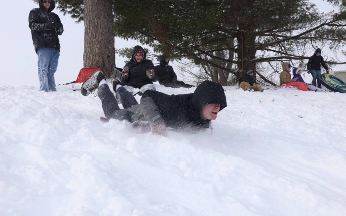 SIU student Vincent Jones races head-first down down a steep hill near the Banterra Center Jan. 25, 2026 in Carbondale, Illinois