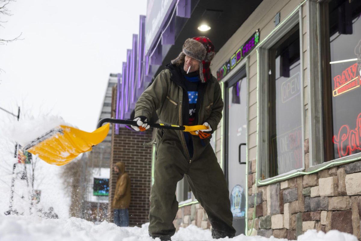Denzel “Shaky” Ridenour, 57, shovels the sidewalk in front of Hollywood 22 Jan. 25, 2026 on The Strip in Carbondale, Illinois.