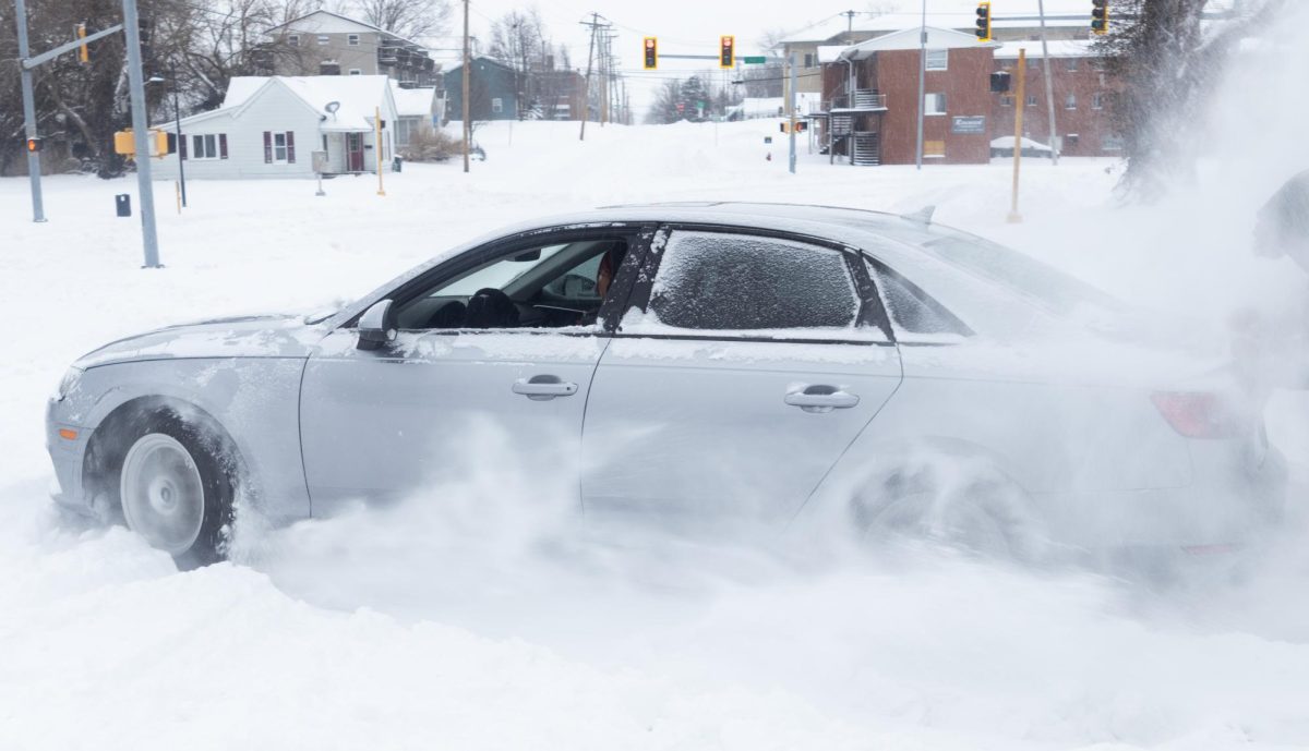 A woman sprays snow as she drives off after being stuck during the winter storm Jan. 25, 2026 in Carbondale, Illinois. Riley Sembler | @riley_sembler