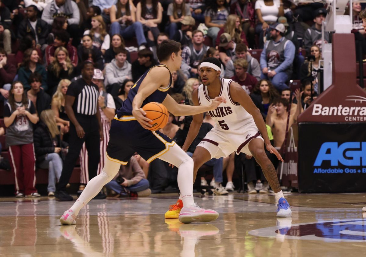Racer Mathis Courbon (2) dribble the ball while Saluki Jalen Haynes (5) stands in front of him Feb. 6, 2026 at the Banterra Center in Carbondale, Illinois. 