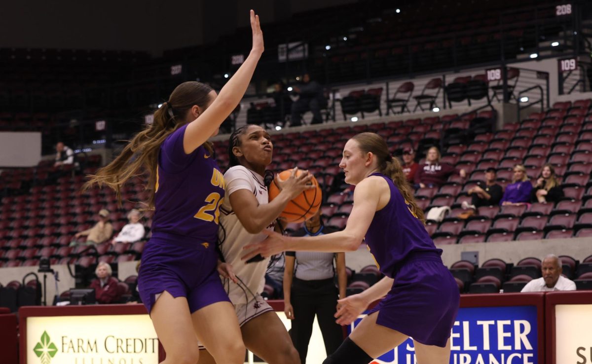 SIU guard Kayla Cooper (14) challenges the defense of two UNI players, Jenna Twedt (20) and Ryley Goebel (5), Feb. 19, 2026 at the Banterra Center in Carbondale, Illinois. 