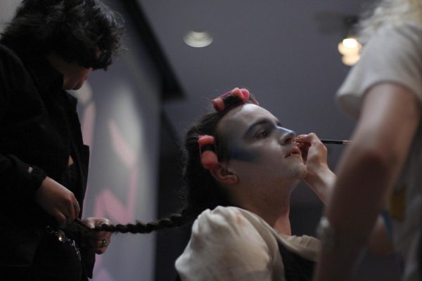 Lee Villarreal braids Dylan Copple's hair as Lily Beer does Copple's eyeliner for their team's look March 30, 2026 during Alt.News 26:46's Drag Race at the SIU Student Center in Carbondale, Illinois.